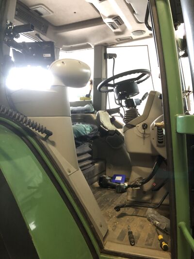 Fendt-cabine tijdens de inbouw van een GPS-stuursysteem, met gereedschap op de vloer