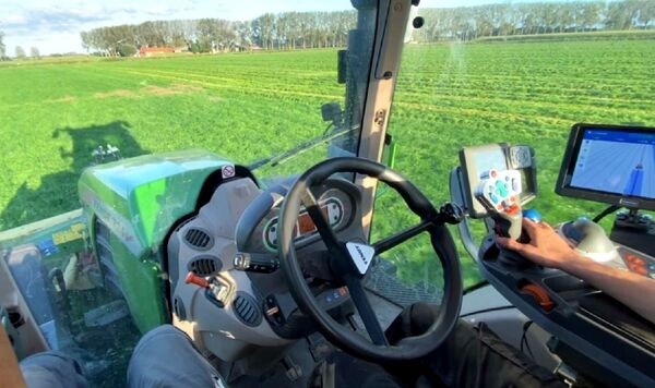 Zicht vanuit een Fendt-cabine: hand op de joystick naast de Agri-GPS-terminal