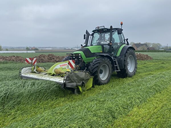 Deutz-Fahr Agrotron met Claas Disco-zijmaaier in een perceel hoog gras