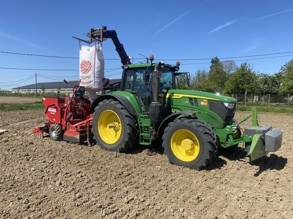 John Deere 6M 155 met Grimme-pootmachine en HZPC-bigbag pootgoed op een akker