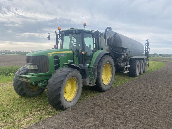 John Deere 6830 met mesttank en sleepslangbemester langs de rand van een perceel